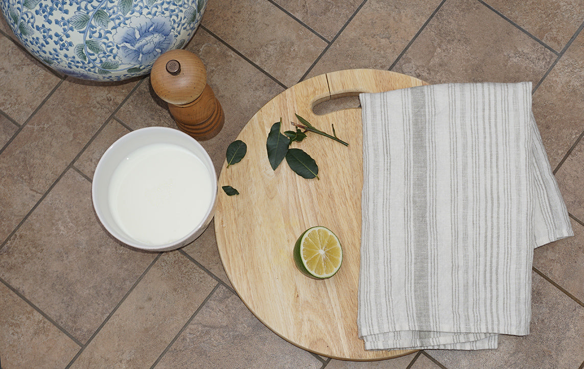 a cutting board with a lime and a UMA HAND towel