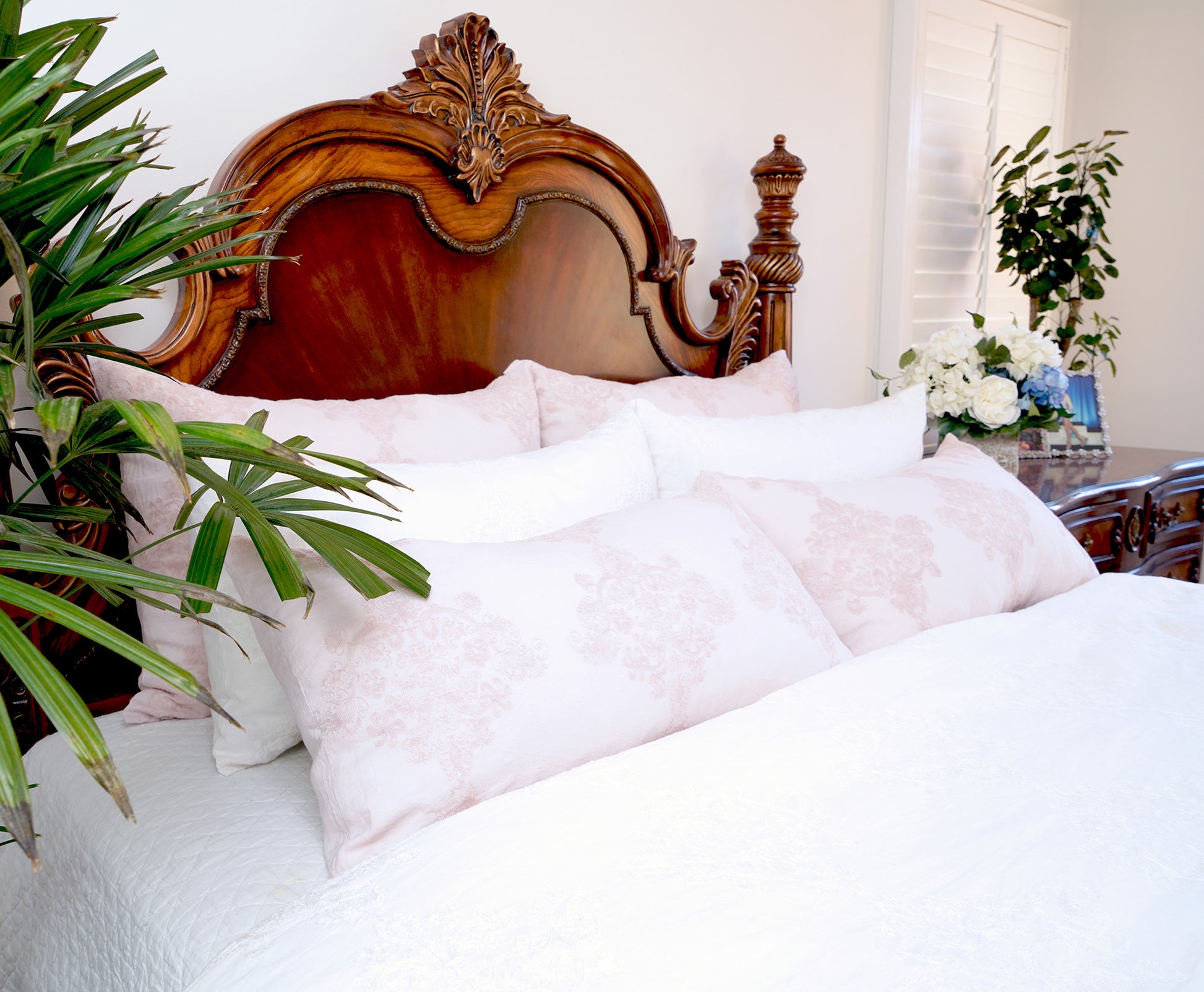 a bed with pillows and a plant