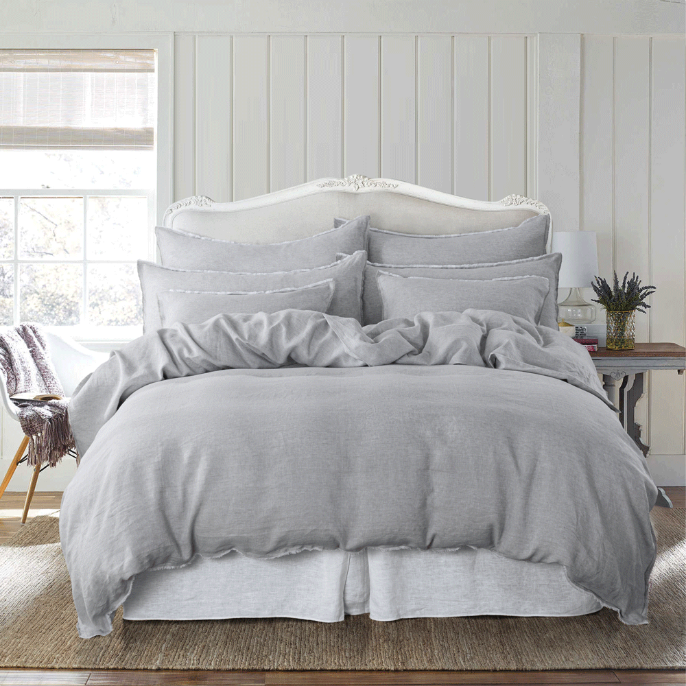 a bed with a white headboard and gray lilah linen duvet cover